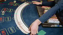 En dealer som cuperar inför ett parti baccarat.